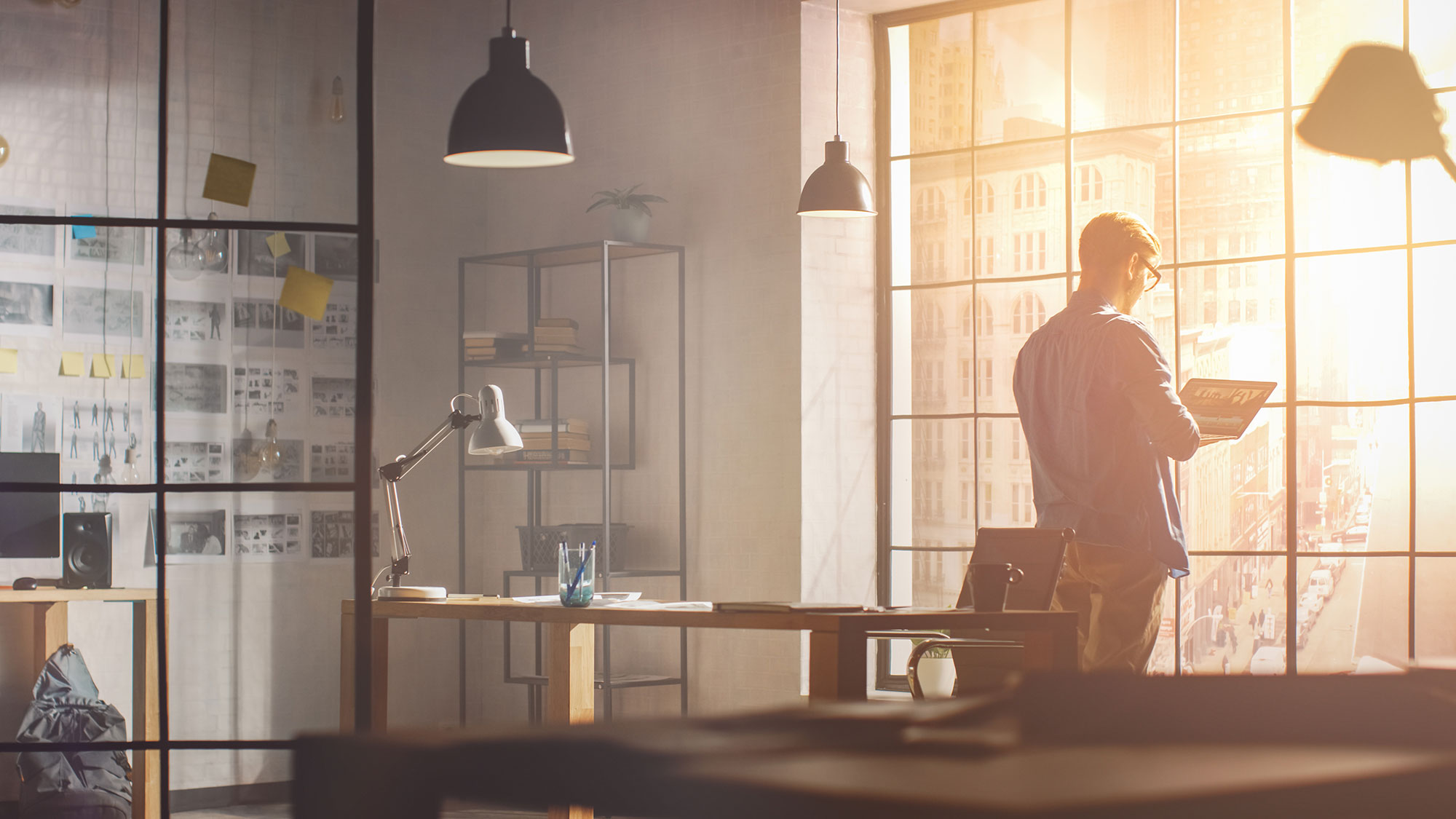 man entrepreneur standing by window in office space