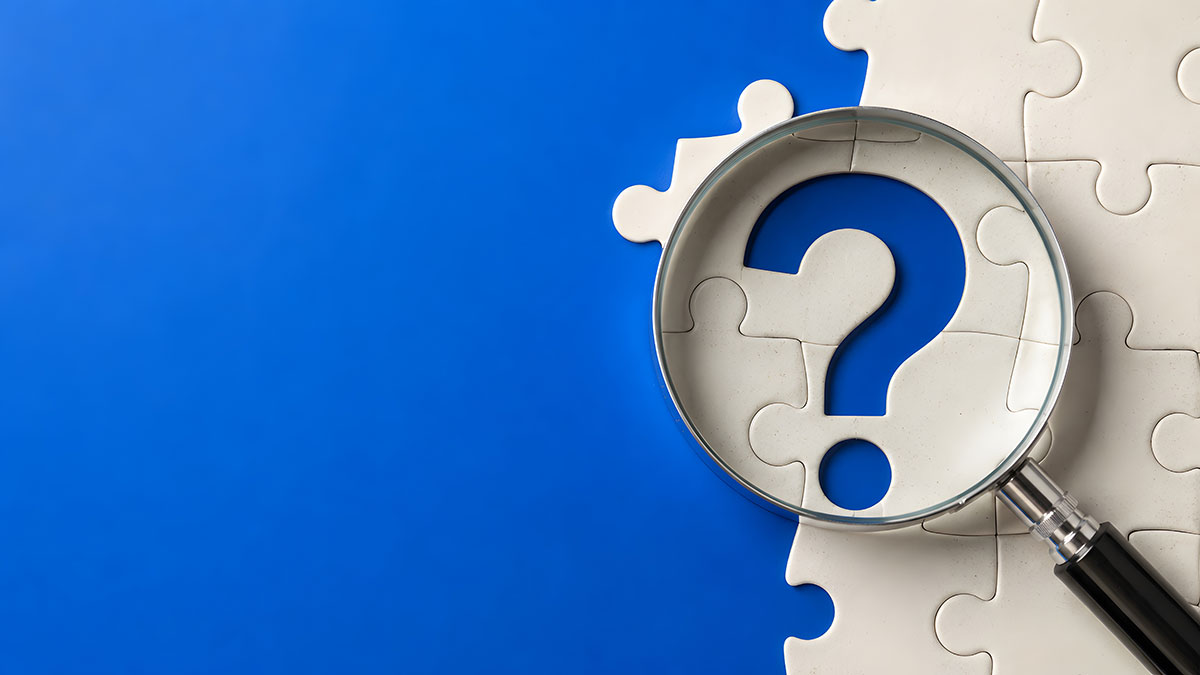 magnifying glass on question mark with puzzle pieces